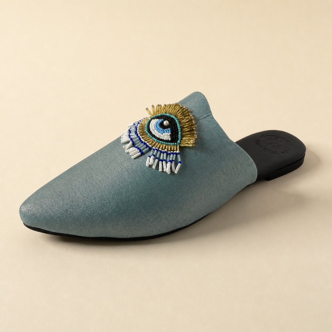 Three-quarter view of the Walkie Walkie Selene powder blue mule showing the hand-beaded evil eye